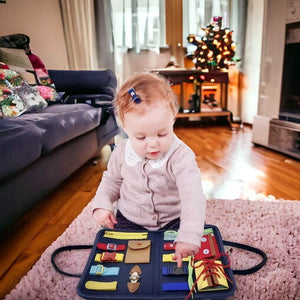 Infant girl playing with a sensory book on the floor in a cozy living room