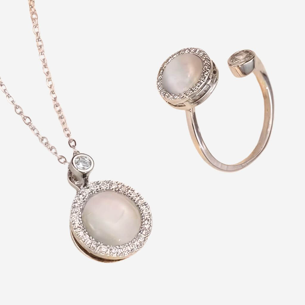 Jewelry set with a necklace and ring featuring cubic zirconia and opal gemstones on a white background.