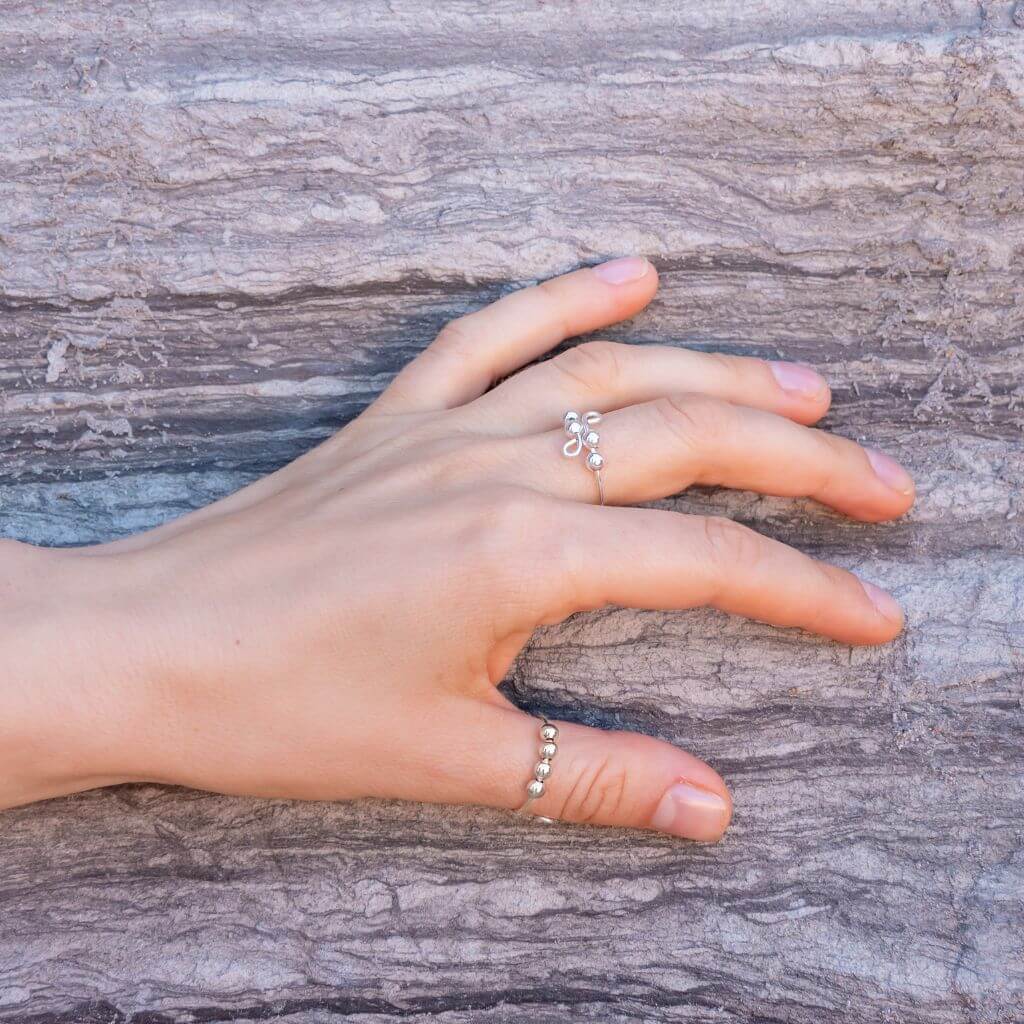 Jewelry for anxiety rings with beads sterling silver on a woman's hand on stone background