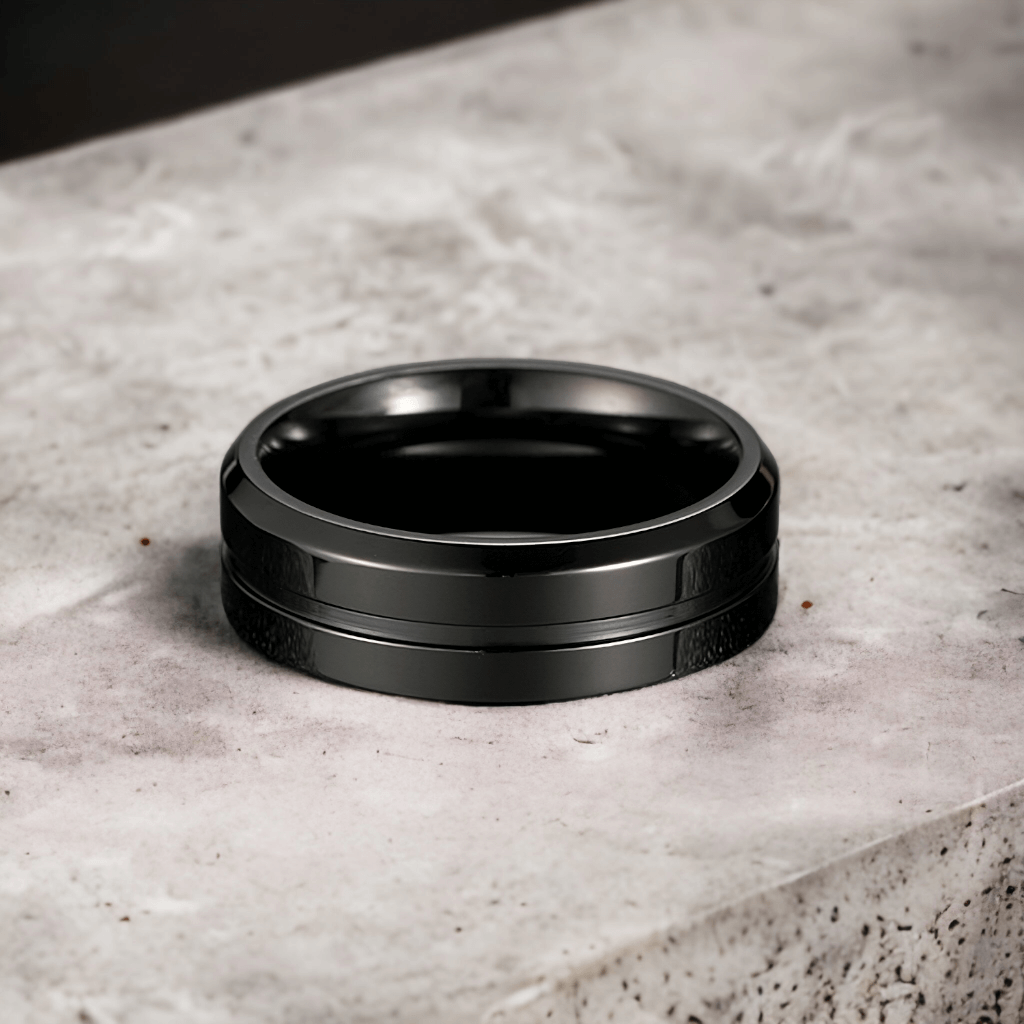 Men's black titanium ring on a grey stone countertop
