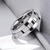 Men's tungsten ring Australia with a textured rotating band on a light gray background