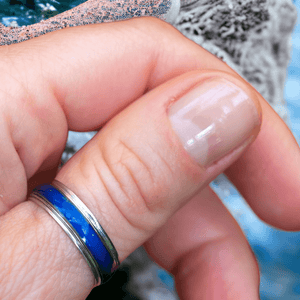 Mood ring with blue band on a thumb close up