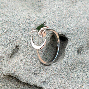 Moon and star adjustable fidget ring on a grey rock