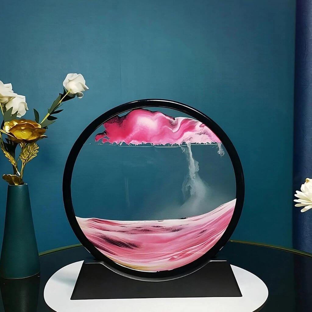 Pink moving sand art in Australia on a white book and teal background