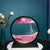 Pink moving sand art in Australia on a white book and teal background