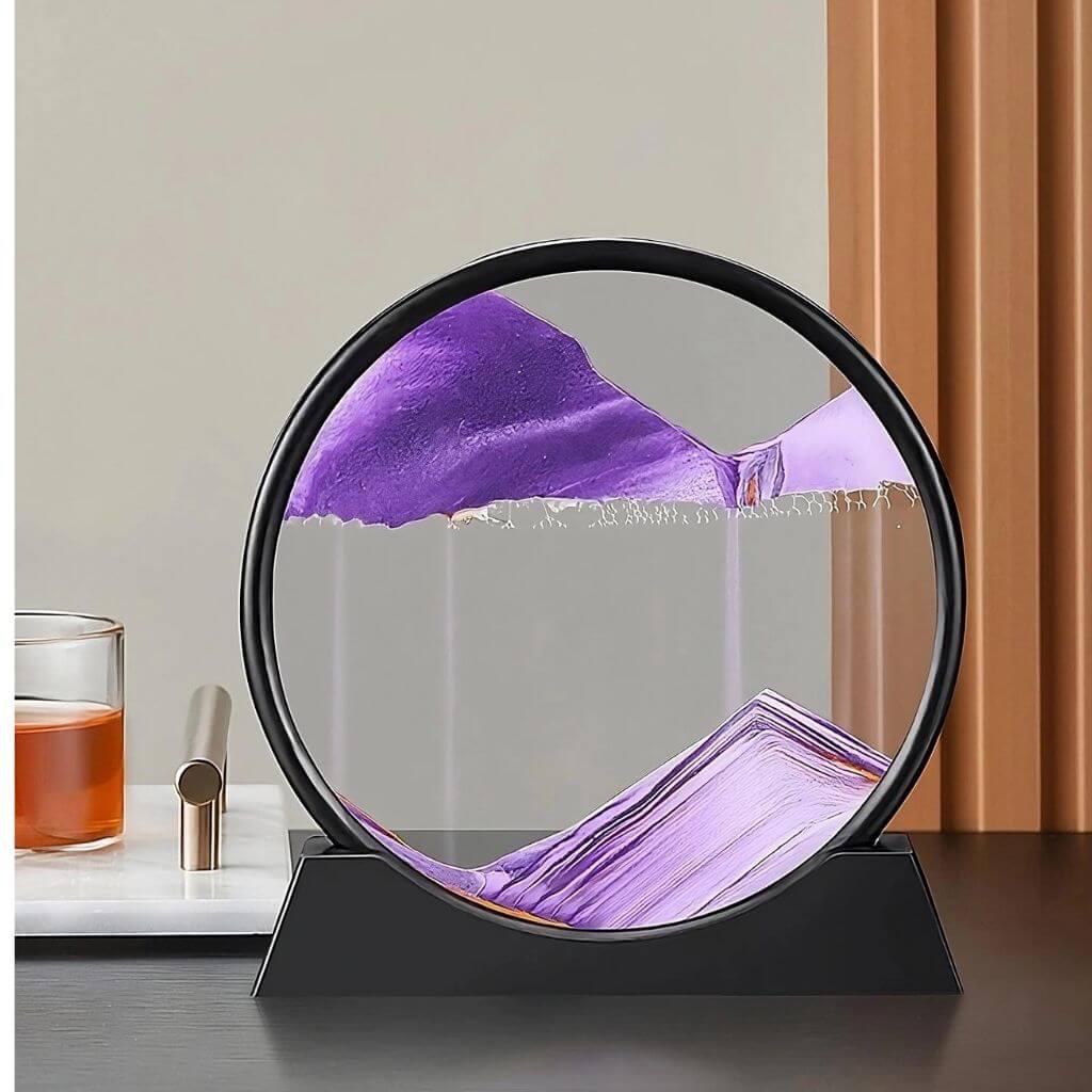 Purple large moving sand art in Australia on a black table and grey background