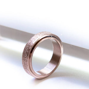 Rose gold stainless steel ring for fidgeting on white background