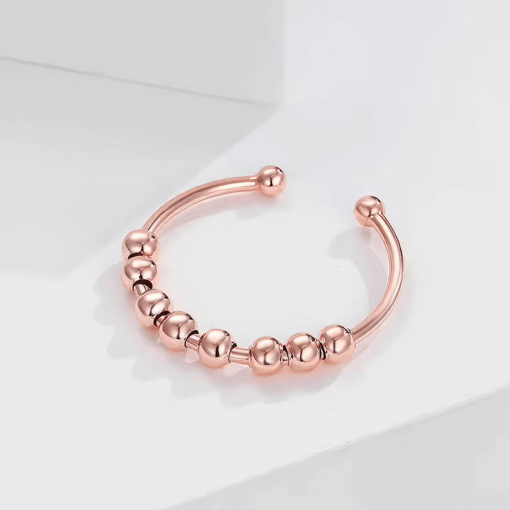 Rose gold sterling silver adjustable ring on a white prop