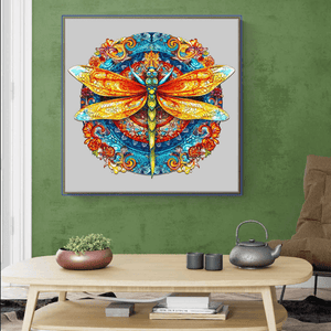 Round wooden puzzle adults dragonfly mandala mounted on a green wall above a coffee table