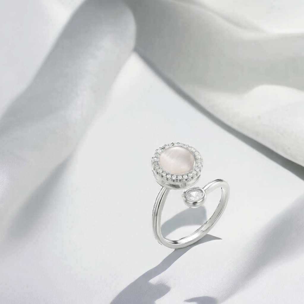 Silver spinning ring on white minimalist background