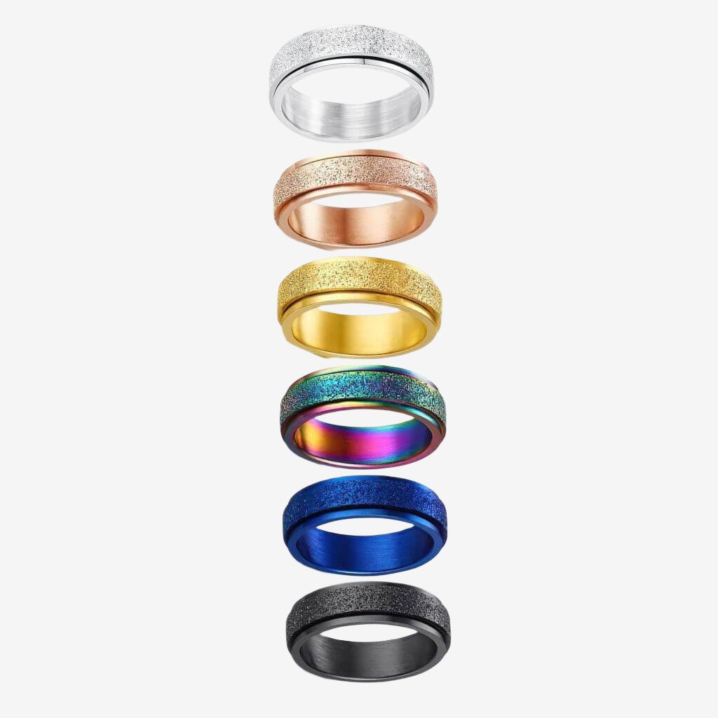 Six multi coloured anti anxiety rings made of stainless steel on white background