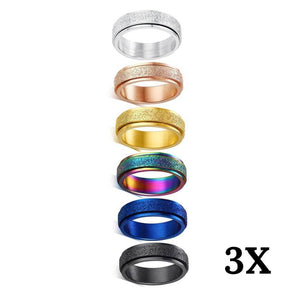 Six multi coloured anti anxiety rings made of stainless steel on white background