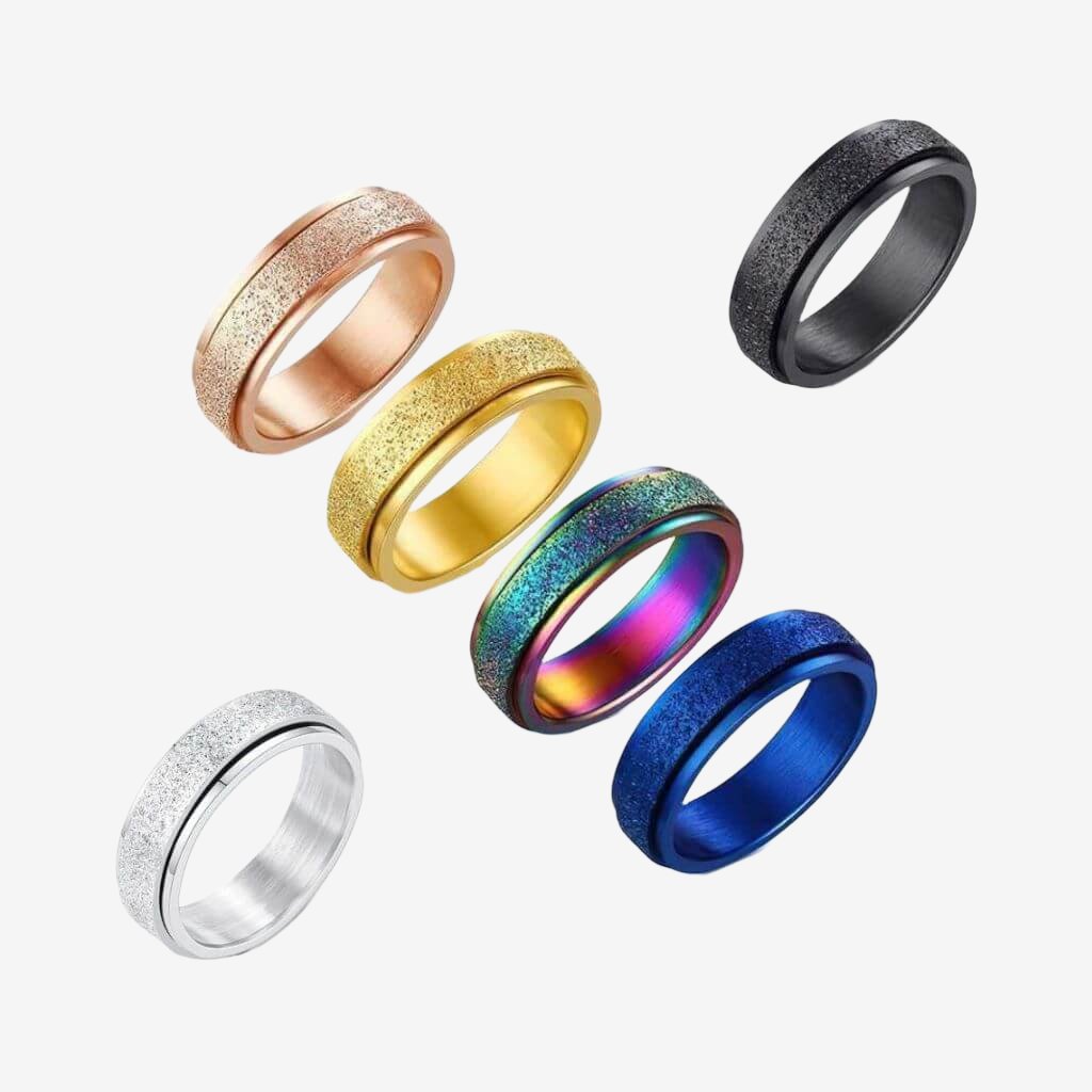 Six multi coloured fidget rings made of stainless steel on white background