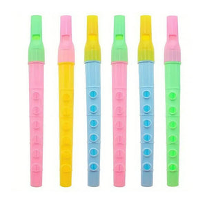 Six multicoloured flute whistles lined up on white background