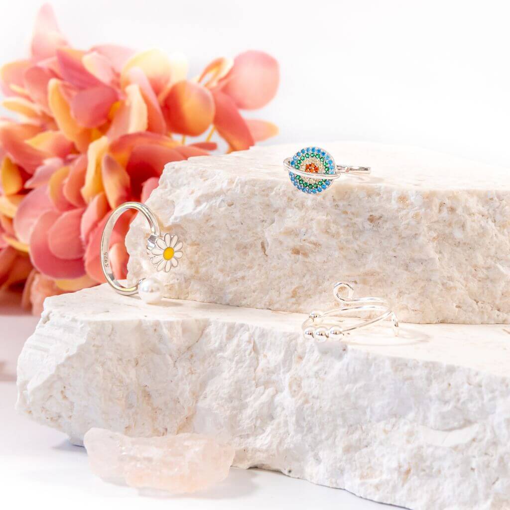 Soothing bundle of 3 women&#39;s spinner rings on a white stone close up