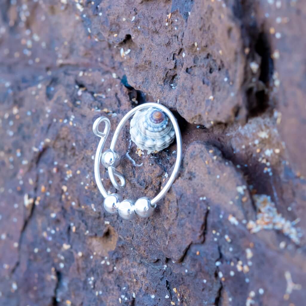 Sterling silver adjustable ring with beads on stone background