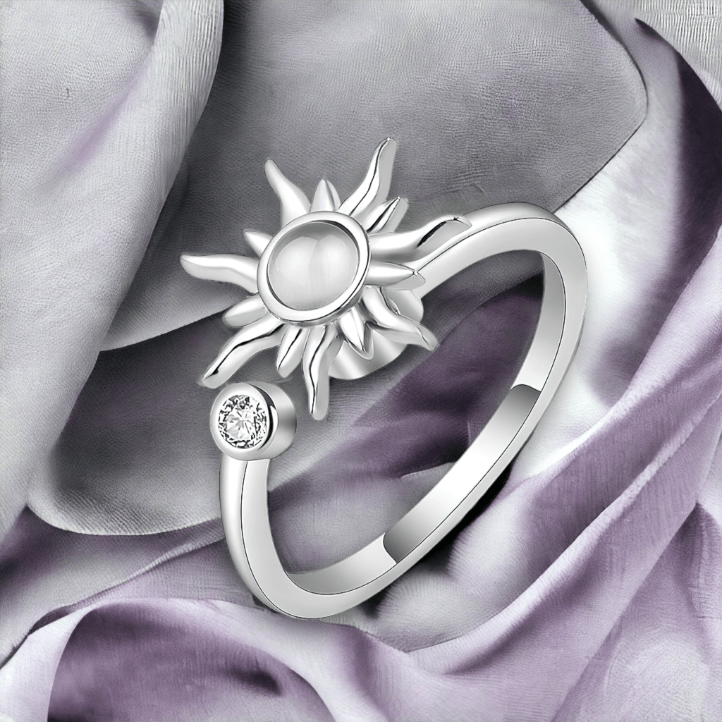 Sun ring with spinning top on grey fabric background