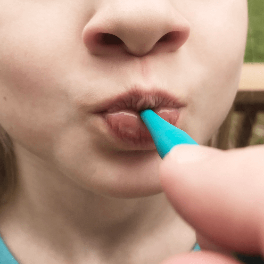 Teal Pro Button Oral Motor Tool by ARK Therapeutic in a child&#39;s mouth