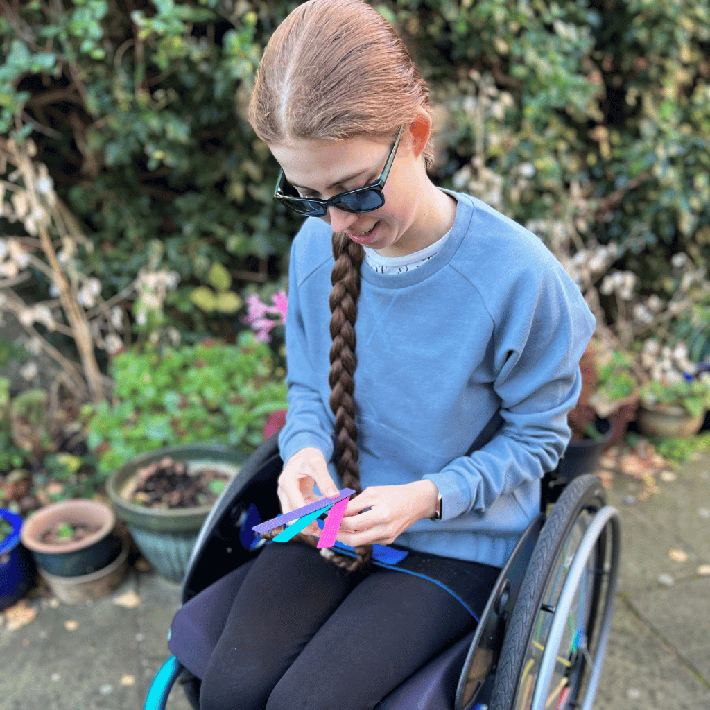 Teenage girl holding three sensory bookmark fidgets
