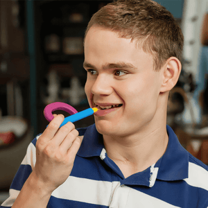 Teenager boy chewing an Ark's Z-Grabber with a textured Bite-n-Chew tip XL