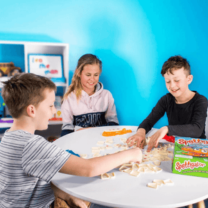Three caucasian children playing spelligator spelling game by Junior Learning at a table