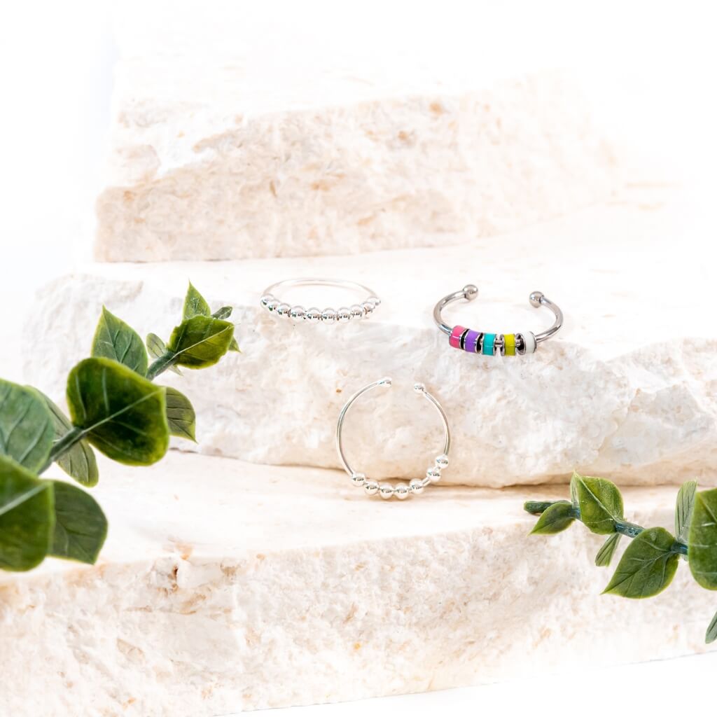 Three fidget rings for adults on a white stone close up