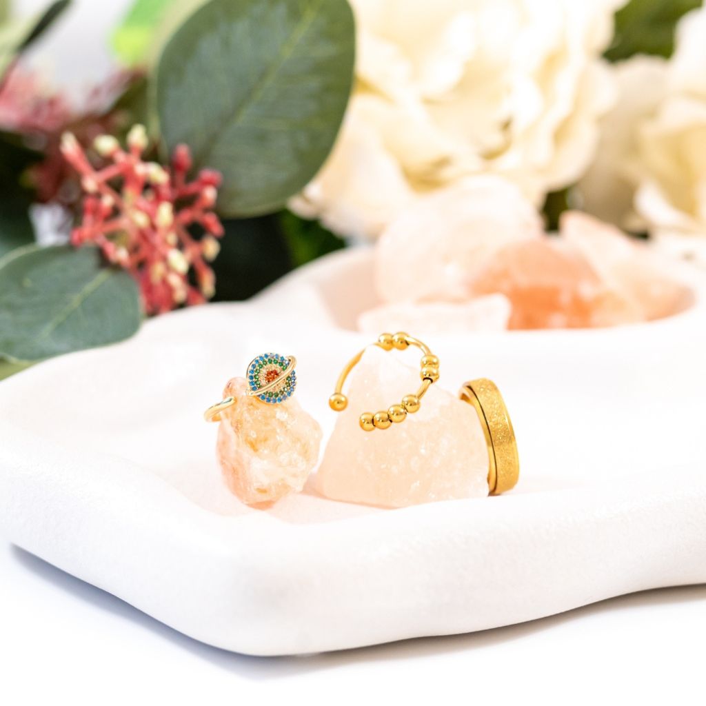 Three gold fidget rings on salt rocks close up