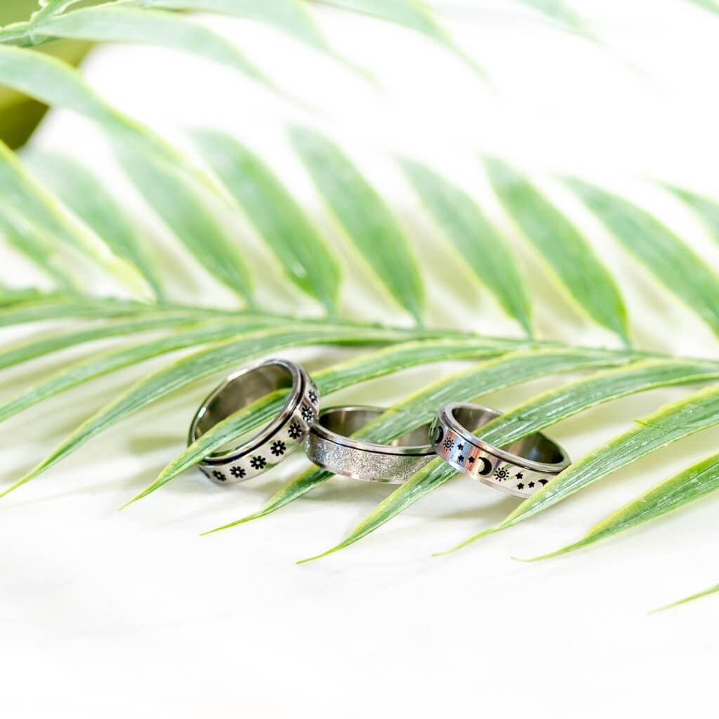 3 stainless steel anxiety rings on a palm leaf
