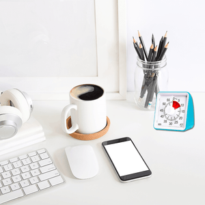 Timer 55 minutes blue on a desk next to a coffee mug, phone, pencils and keyboard