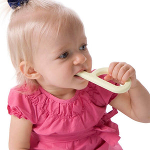 Toddler girl chewing a yellow silicone teether from Ark