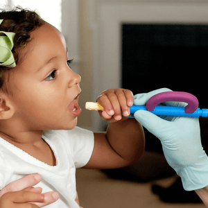 Toddler girl holding Ark's Z-Grabber with a textured Bite-n-Chew tip XL