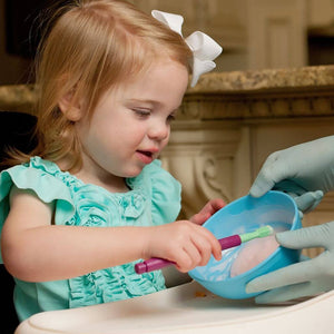 Toddler girl scooping food with a Ark Therapeutic Mini Tip for Z Vibe 