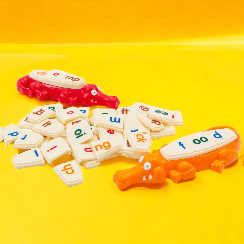 Two alligators and letter tiles from Spelligator board game by Junior Learning on yellow background