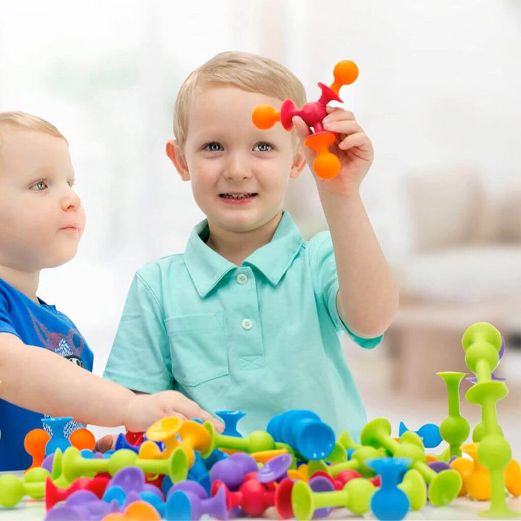 Two Caucasian boys playing with Suction toys