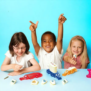 Two girls and a boy playing Spelligator board game by Junior Learning at a table