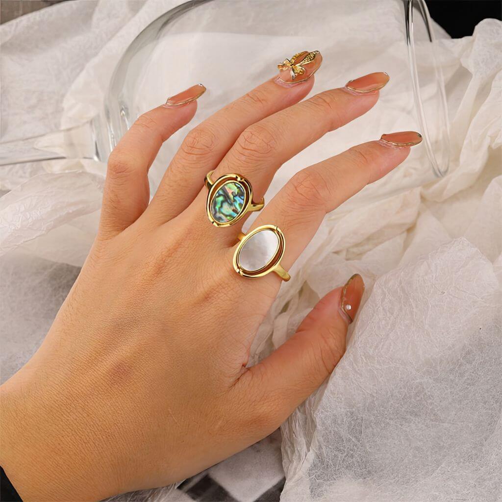 Two gold abalone rings on a woman&#39;s hand