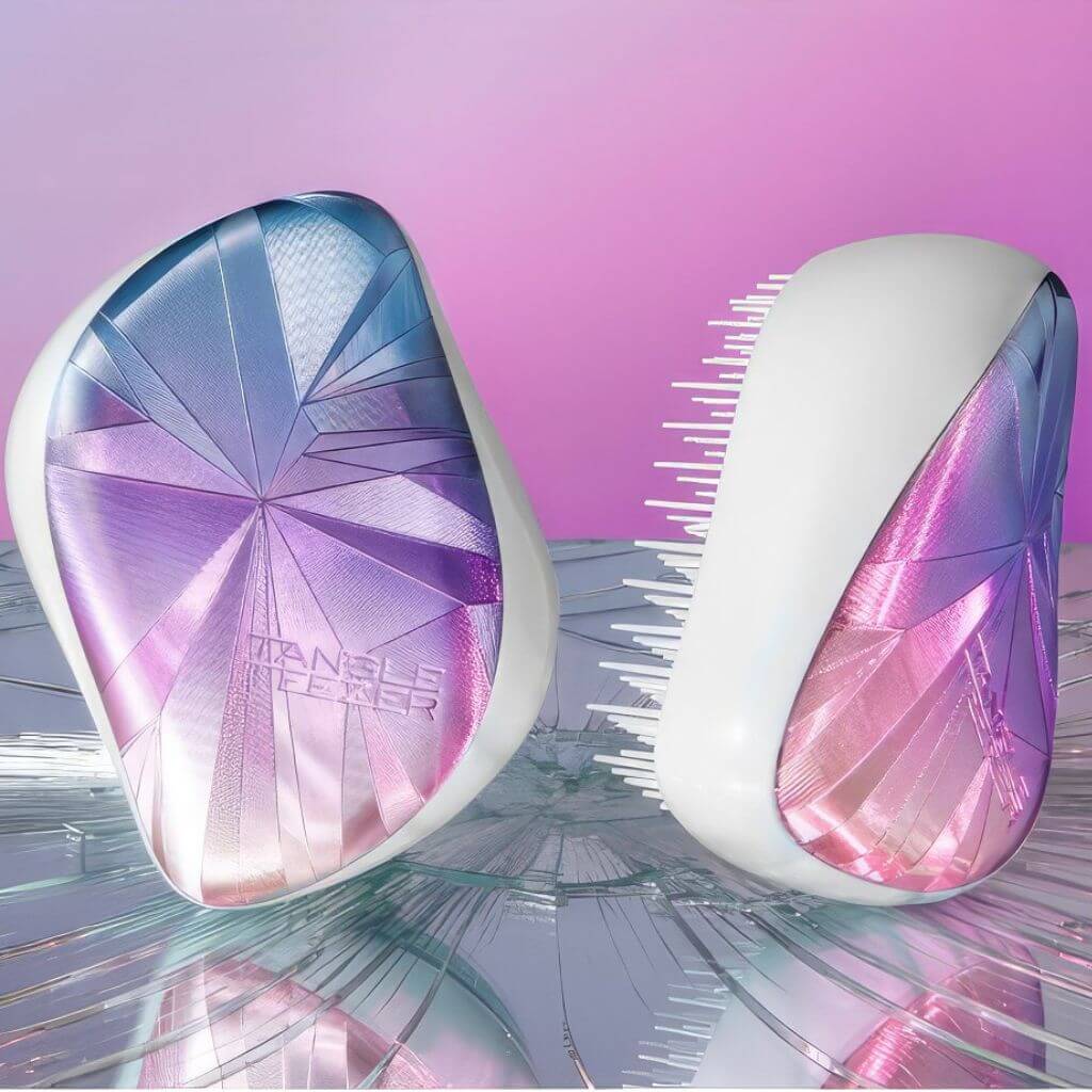 Two travel hair brushes on a shattered mirror