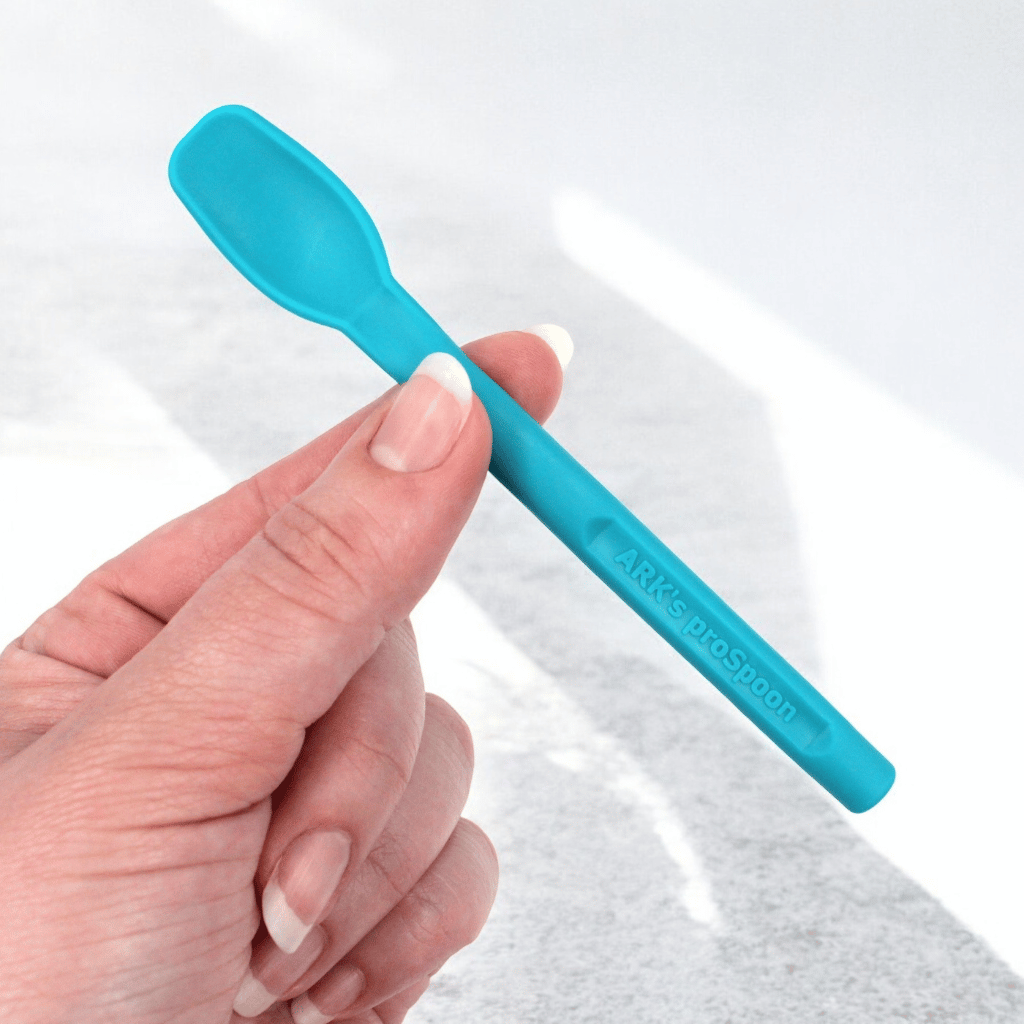 Woman&#39;s hand holding Ark-s smooth proSpoon teal