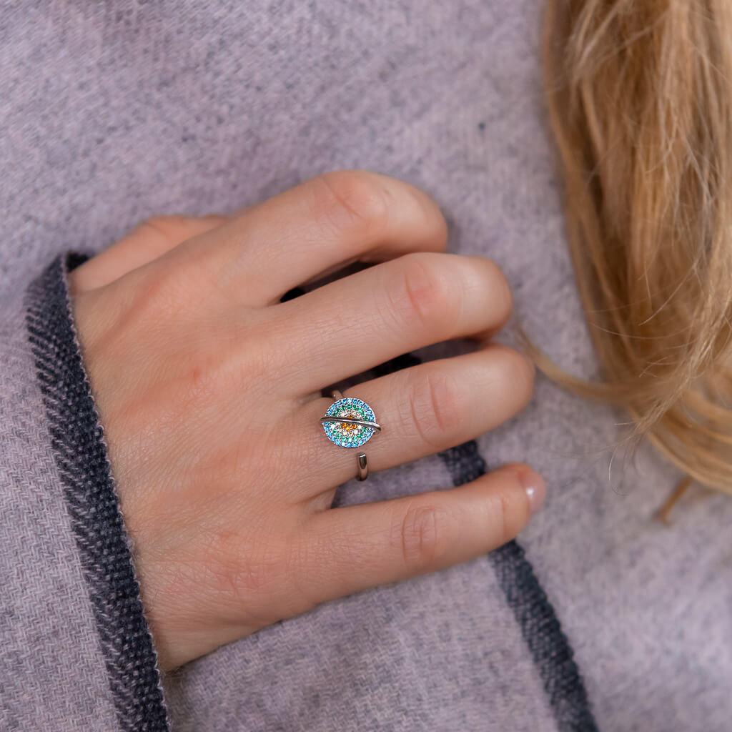 Woman wearing a planet anxiety ring that spins in silver on grey shawl 