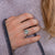Woman wearing a planet anxiety ring that spins in silver on grey shawl 