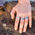 Woman's hand on a rock wearing 3 stainless steel band fidget rings