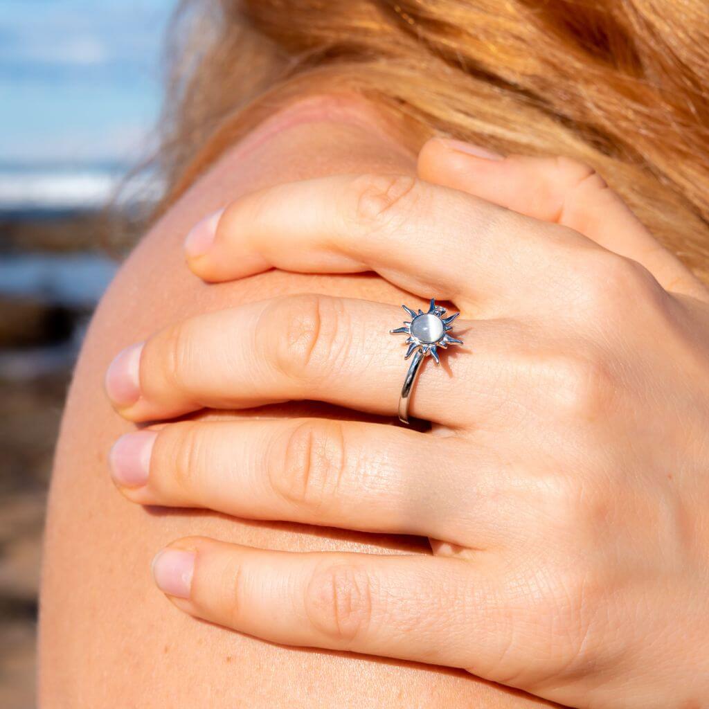 Woman&#39;s had on her shoulder wearing a sun ring with spinning top