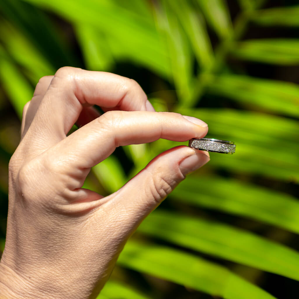 Woman holding a silver sparkly spinning ring Australia on green 