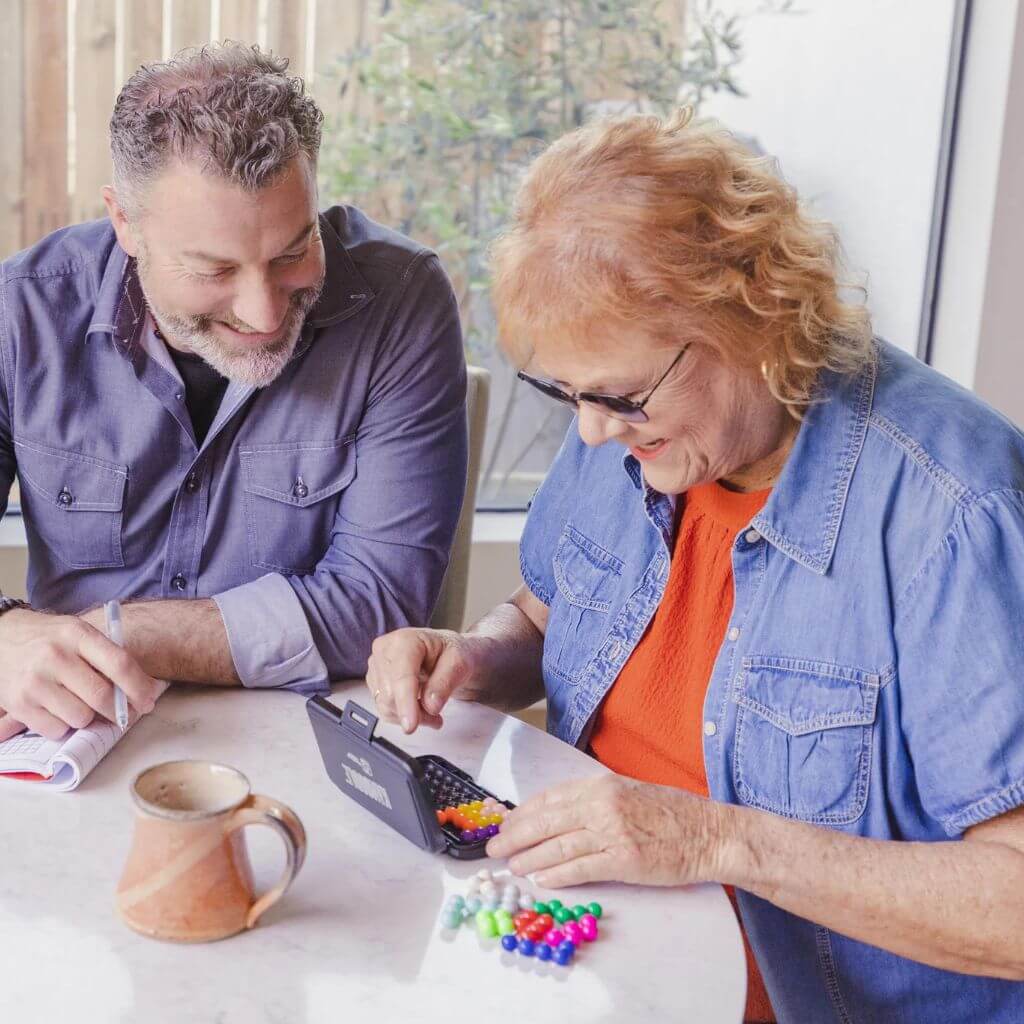 Woman and man seniors playing Kanoodle game from Educational Insights