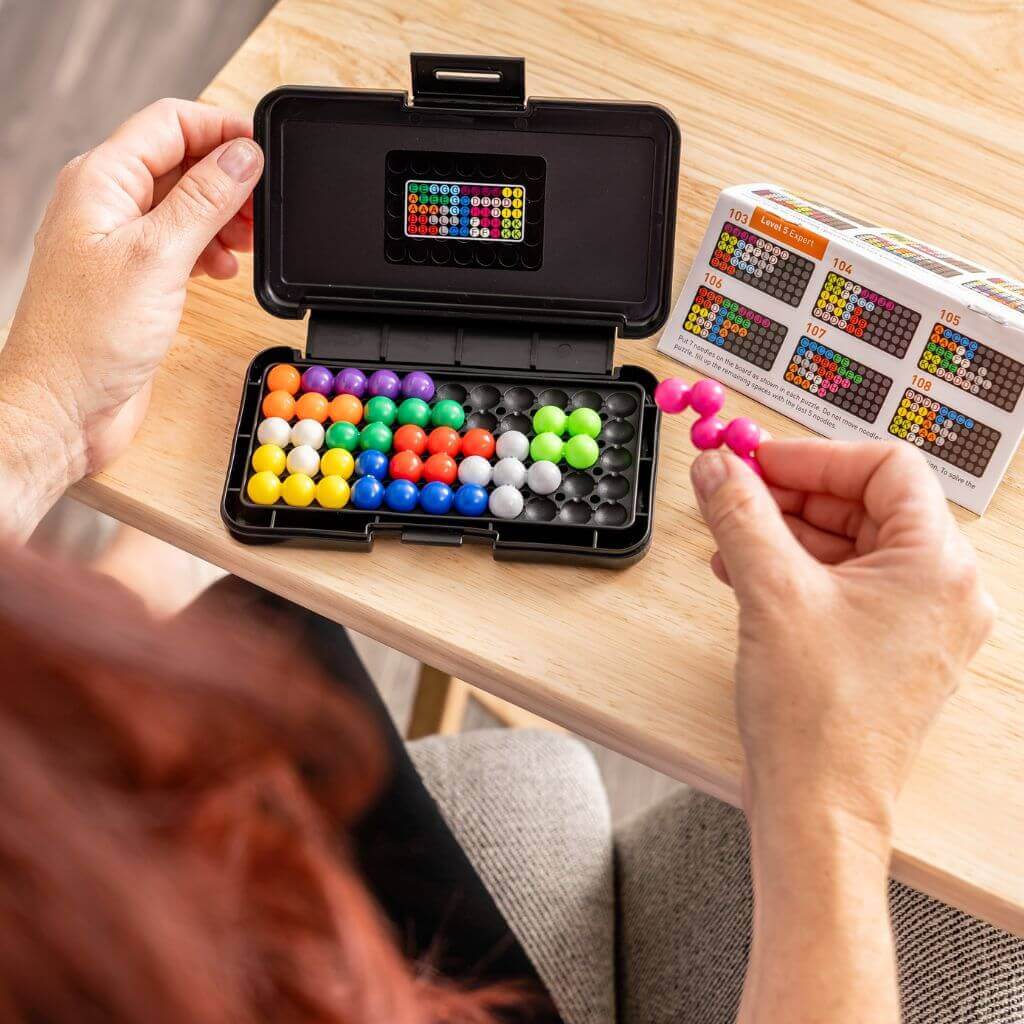 Woman playing with Educational Insights Kanoodle board game 200 puzzles