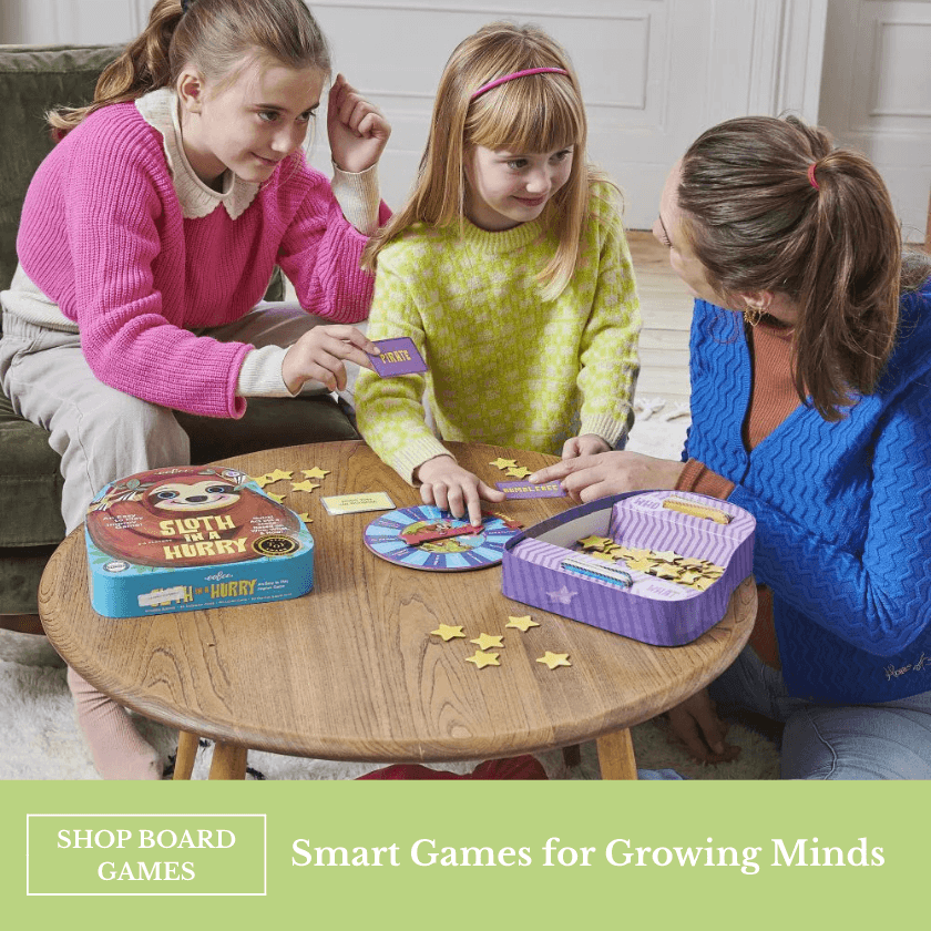 Woman and two girls playing a board game at a table