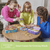 Woman and two girls playing a board game at a table