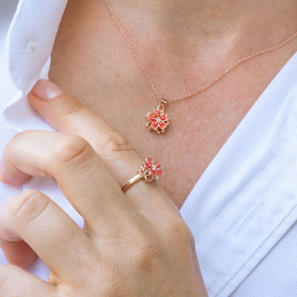 Roman in white shirt wearing a fidget necklace and a ring with flower top