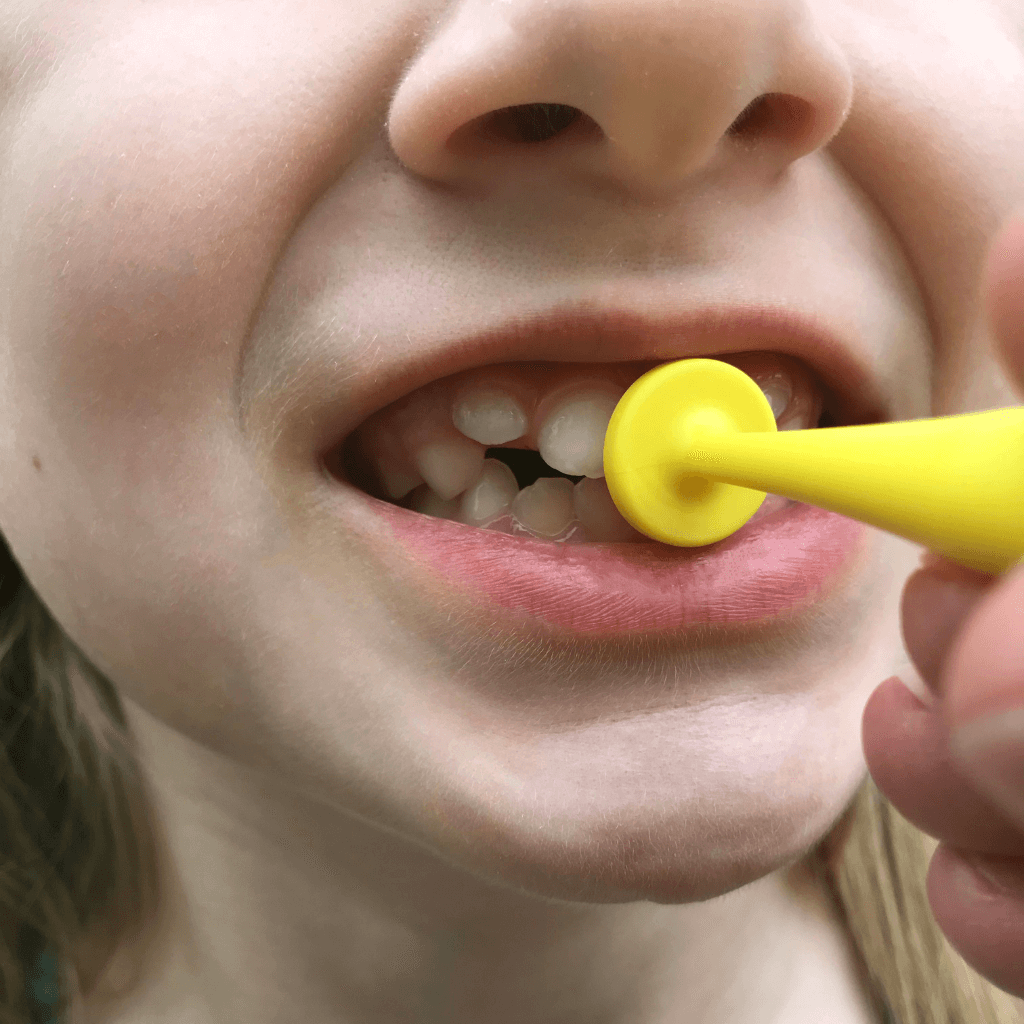 Yellow Pro Button by Ark in a child's mouth