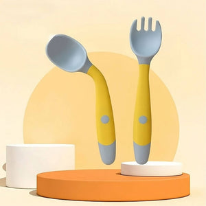 Yellow baby feeding set with flexible handles on a background with geometric shapes